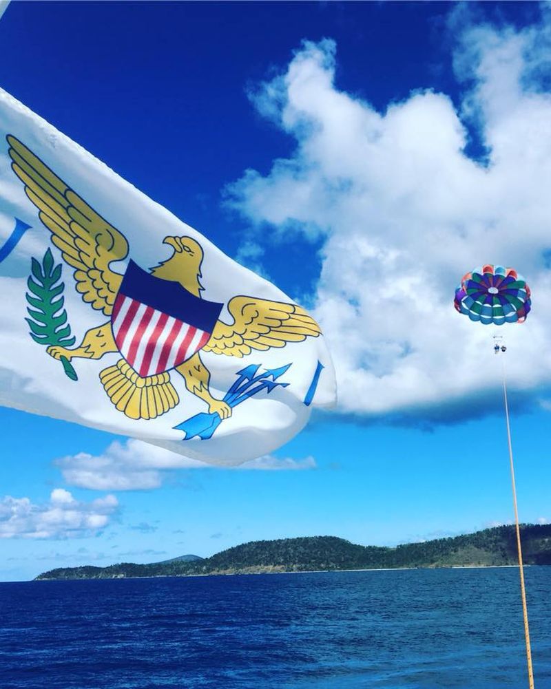 Colorful parasail over Christiansted harbor with the USVI flag in the foreground